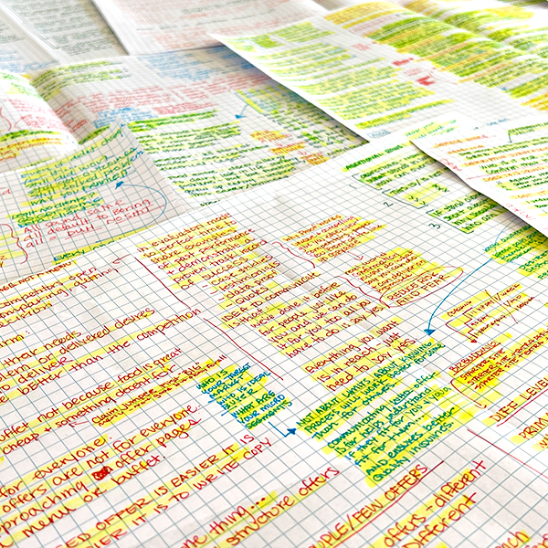 Brand copywriting and content writing notes written by hand in multiple ink colors, on large sheets of paper, with some words highlihts