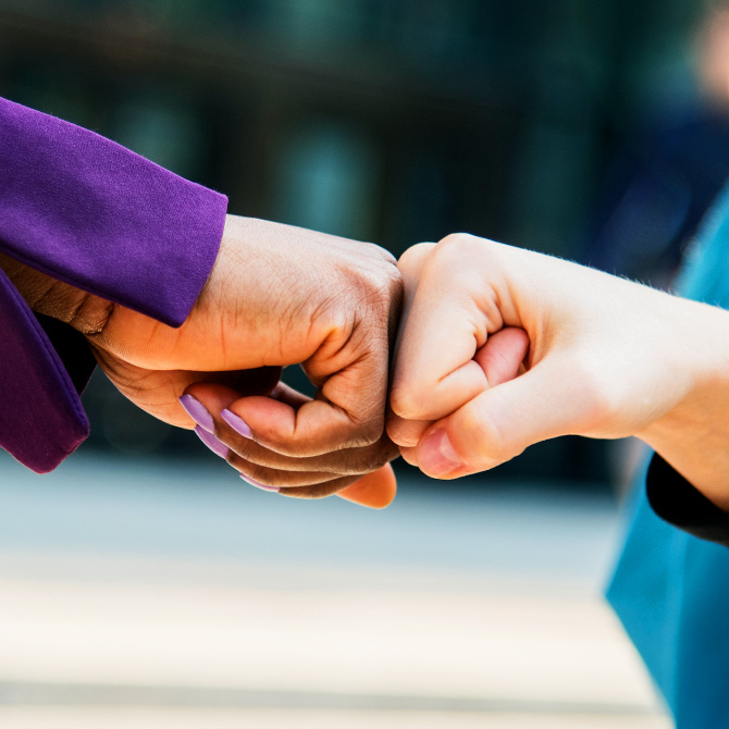 Two women bumping fists in agreement