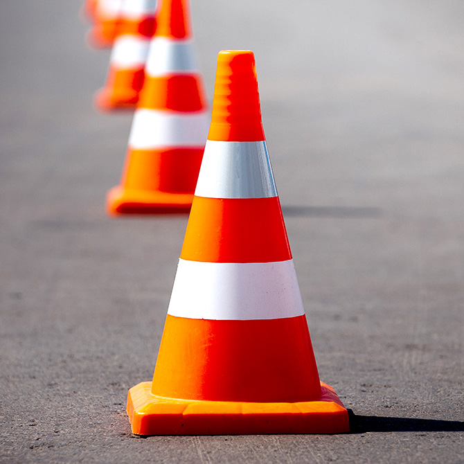 Bright orange traffic cones representing the boundary we hold with what AI cannot do and what we will not use AI for