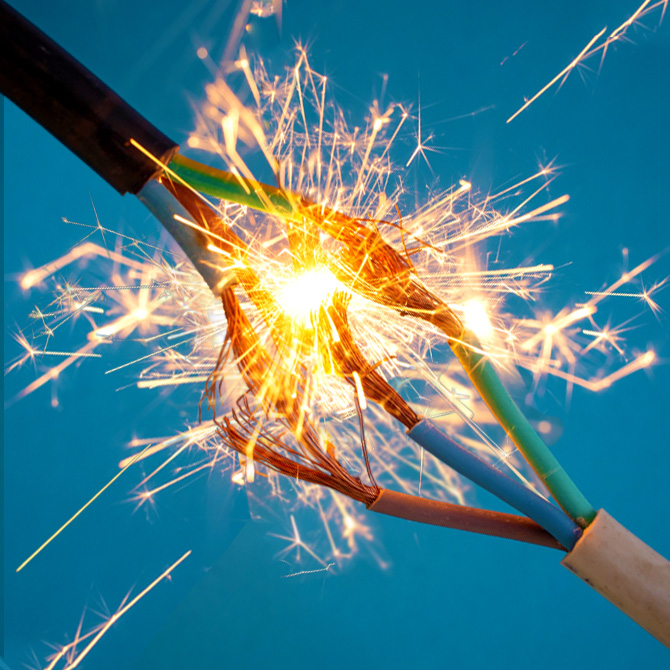 Wires coming together and creating sparks to represent using AI as a tool to expand human capabilities