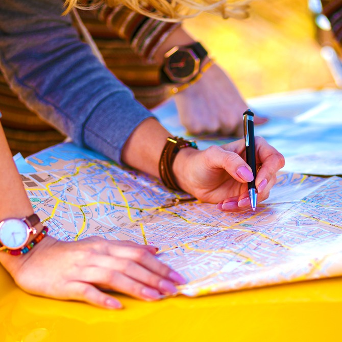 Two people planning their road trip route on a roadmap just as a website content strategist plans a website's content